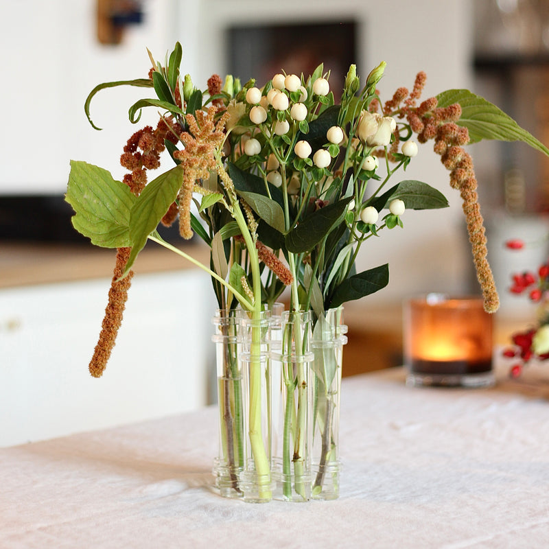 Een Flowerflute vaas van Hanataba gevuld met een arrangement van gemengde seizoensbloemen en bladgroen.