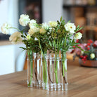 Elegante Flowerflute vaas van Hanataba met een arrangement van verse witte rozen op een houten tafelblad.